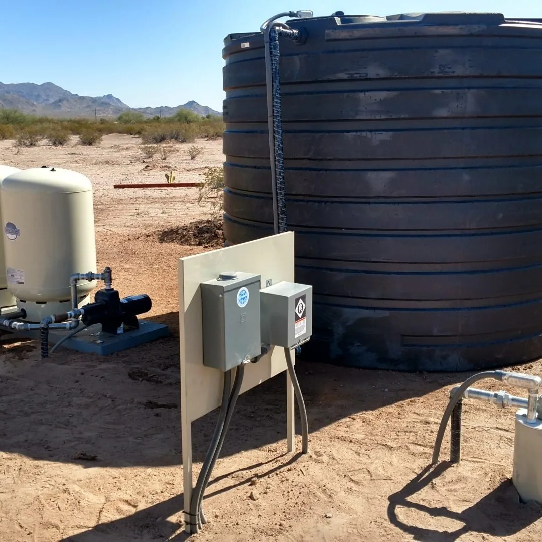 A storage tank, two pressure tanks, a booster pump and control boxes installed on a desert property