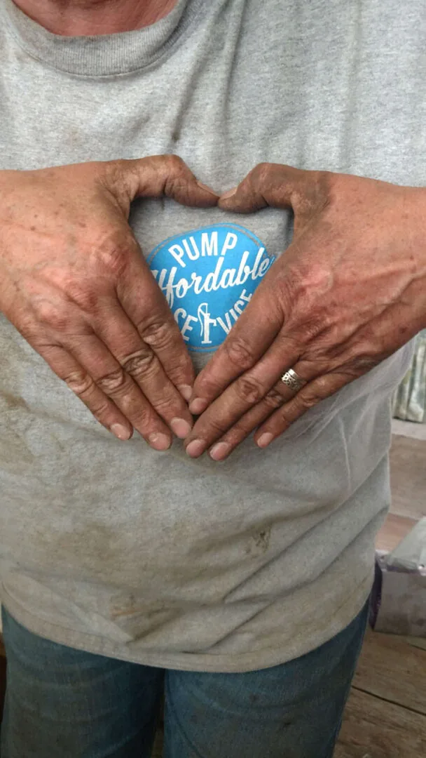 A customer’s hands shaped into a heart around the Affordable Pump Service logo